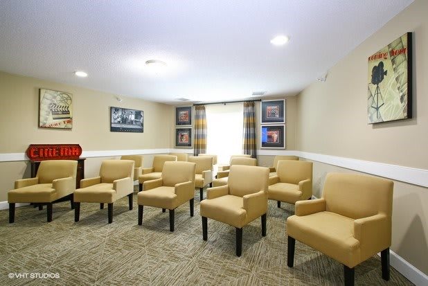 A small conference room with arranged chairs and framed pictures on the walls.