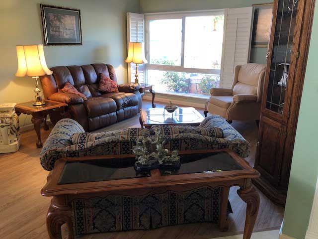 A cozy living room with sofas, a coffee table, and warm lighting.