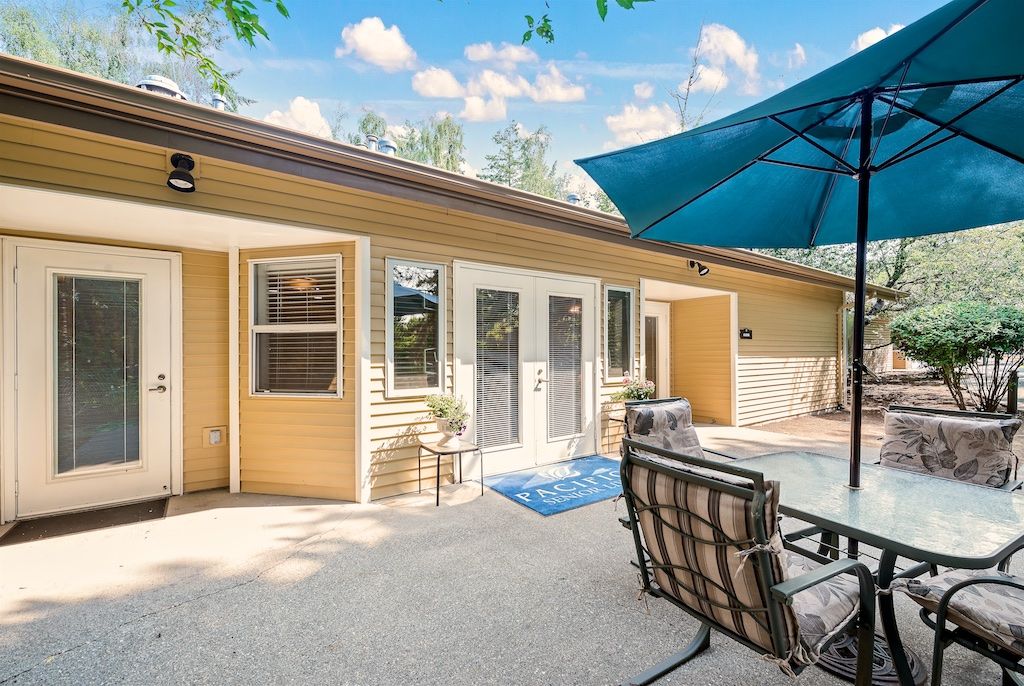 A cozy outdoor patio area with seating and a large umbrella.