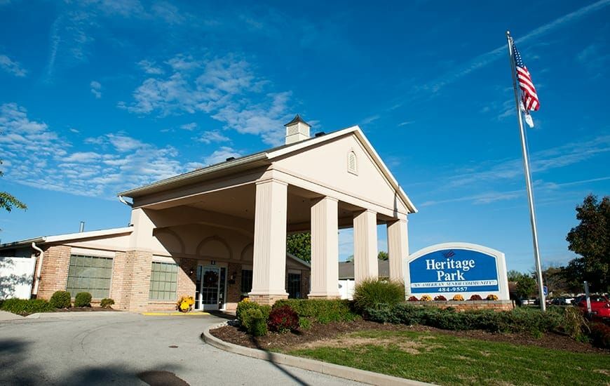 A classic pavilion-style building entrance with columns, featuring a prominent sign on the right.