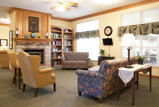 A cozy living room with comfortable seating, bookshelves, and a fireplace.