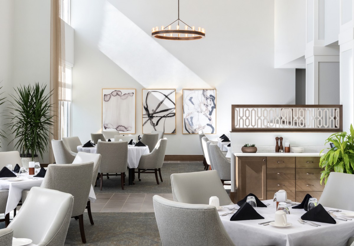 A modern restaurant dining area featuring elegant decor with contemporary artwork and stylish furnishings.