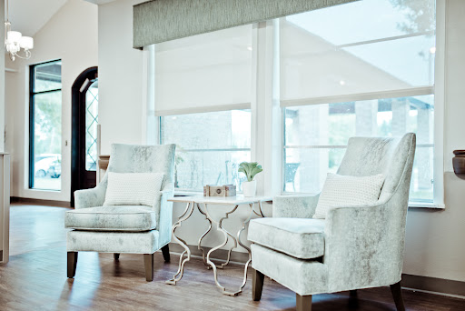 A serene corner of a modern living room featuring stylish chairs and a decorative table, bathed in natural light.