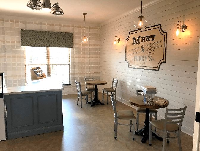 Cozy cafe interior with tables and chairs, featuring vintage-style signage.