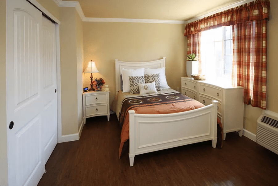 A cozy bedroom with classic white furniture and a warm, inviting atmosphere.
