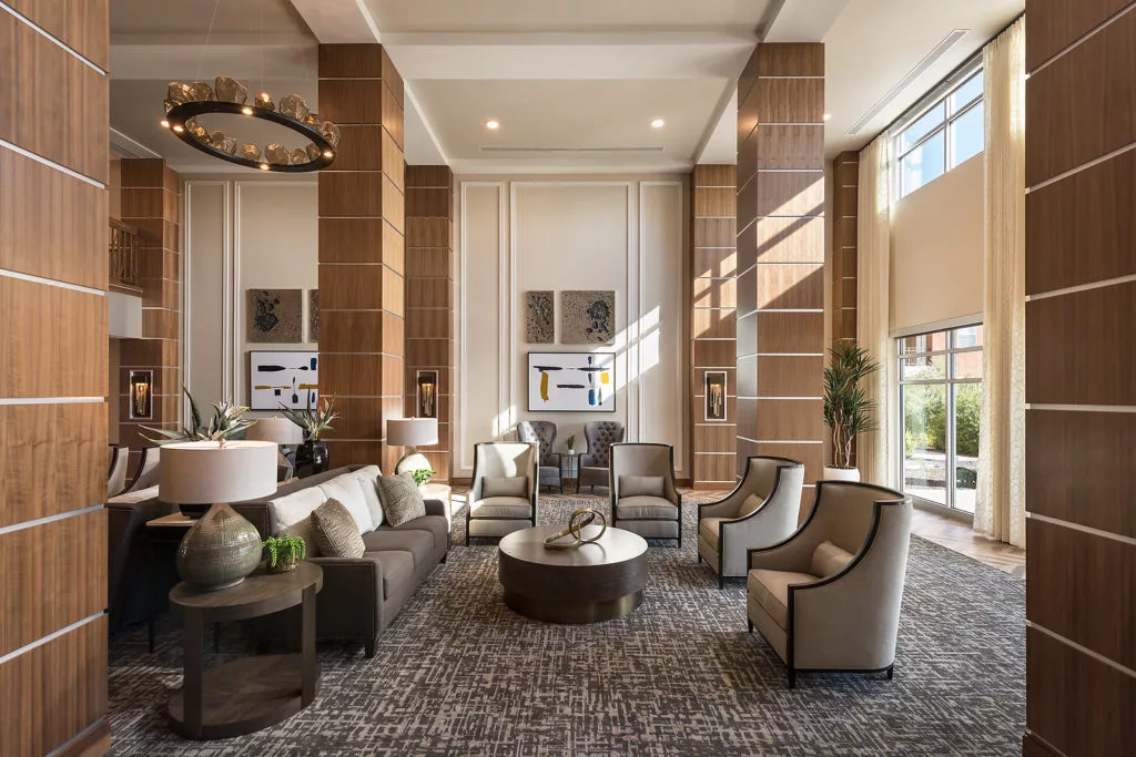 A luxurious and modern lobby with an inviting seating area, featuring large windows that allow natural light to illuminate the space.