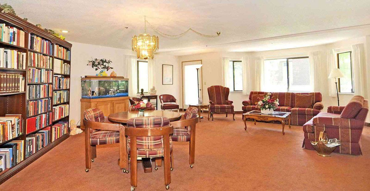 A spacious living room with classic wooden furniture and an aquarium.