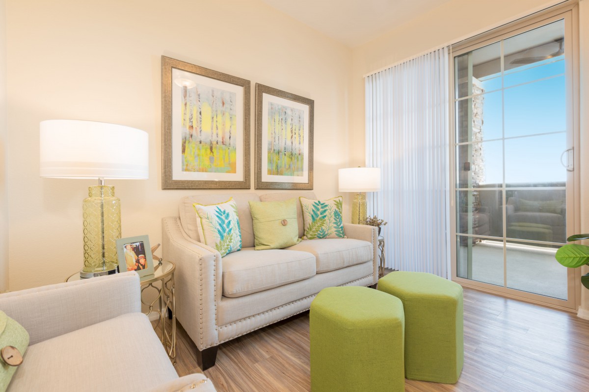 A modern living room with a comfortable sofa, vibrant green accents, and stylish artwork.