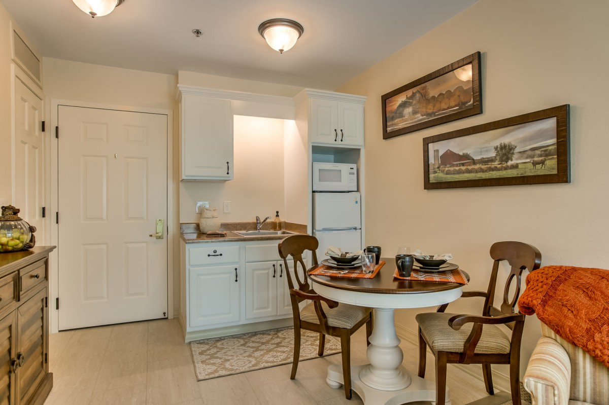 A cozy kitchen and dining area featuring a small round table with chairs, set in a compact apartment space.