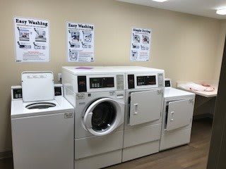 A laundry room equipped with washing machines and dryers.