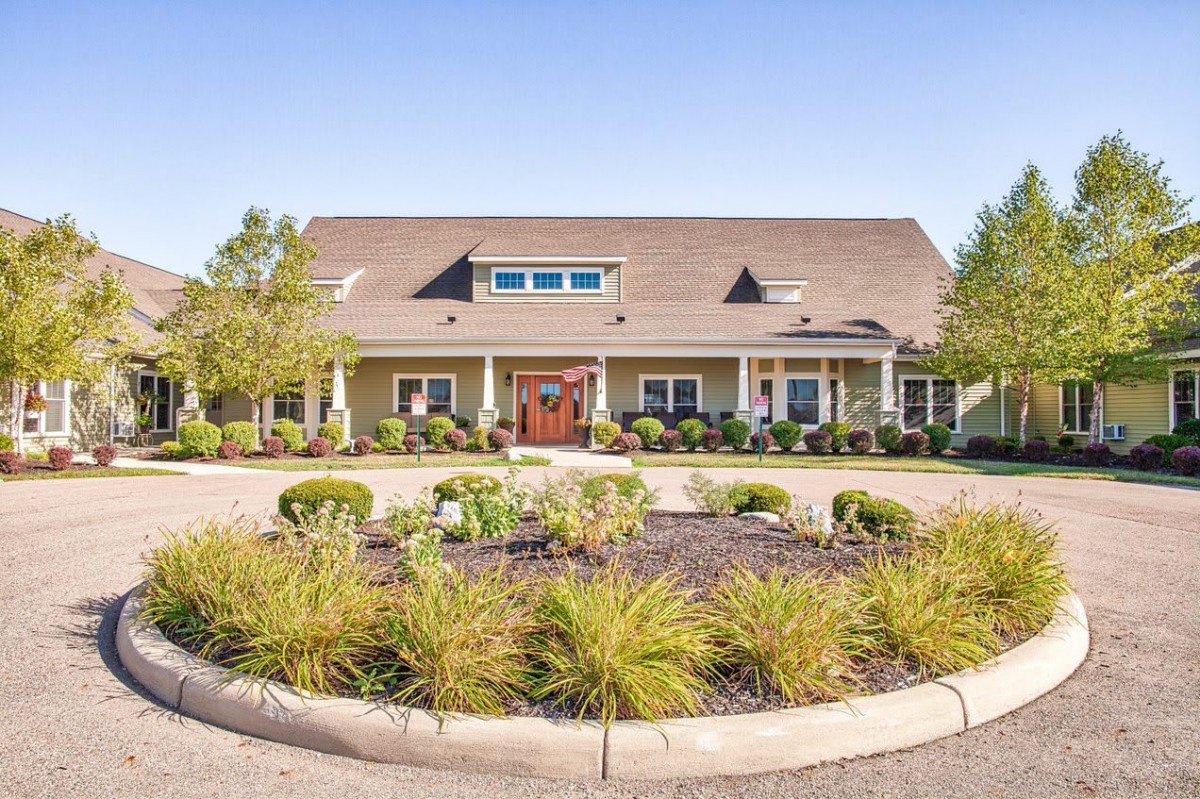 A well-maintained suburban house with a landscaped front yard and circular driveway.