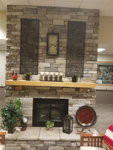 A cozy fireplace setup featuring a stone wall and decorative elements.