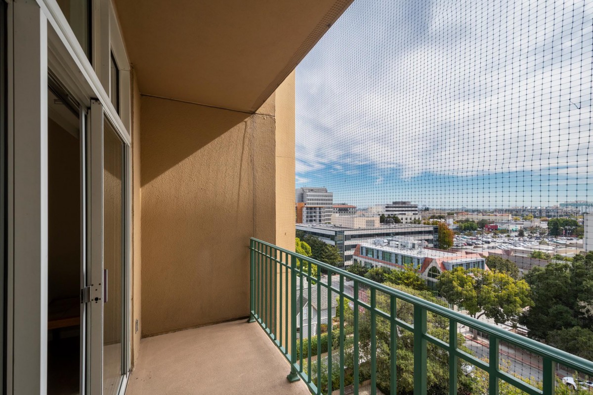 A cozy apartment balcony overlooking a vibrant cityscape.