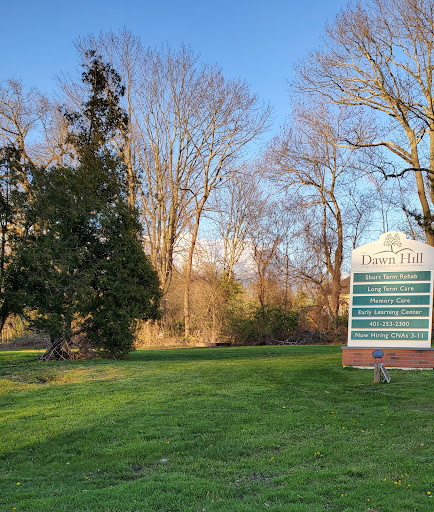 A peaceful park scene featuring trees and a sign, bathed in warm sunlight.