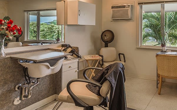 An interior view of a cozy hair salon with styling chairs, mirrors, and hairdressing equipment.