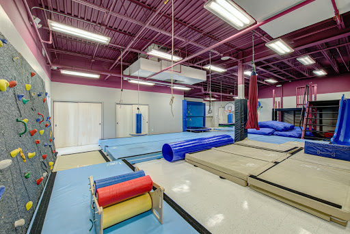 A well-equipped gymnastics training facility featuring colorful exercise mats and various apparatus for training.