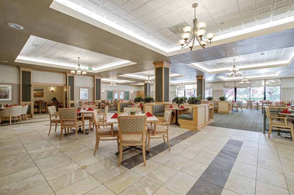 A spacious dining area with contemporary furnishings and elegant chandeliers.