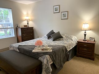 A cozy bedroom with a neatly made bed, bedside tables with lamps, and elegant decor.