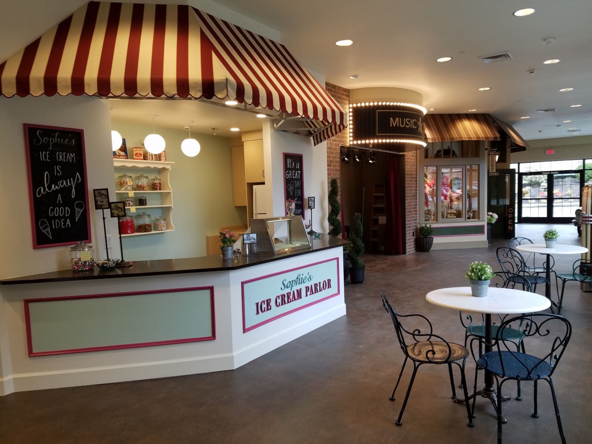 A cozy indoor ice cream parlor with a striped awning and seating area.