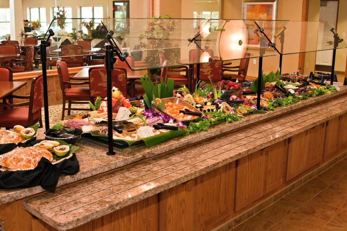 A restaurant buffet with a variety of food options displayed.