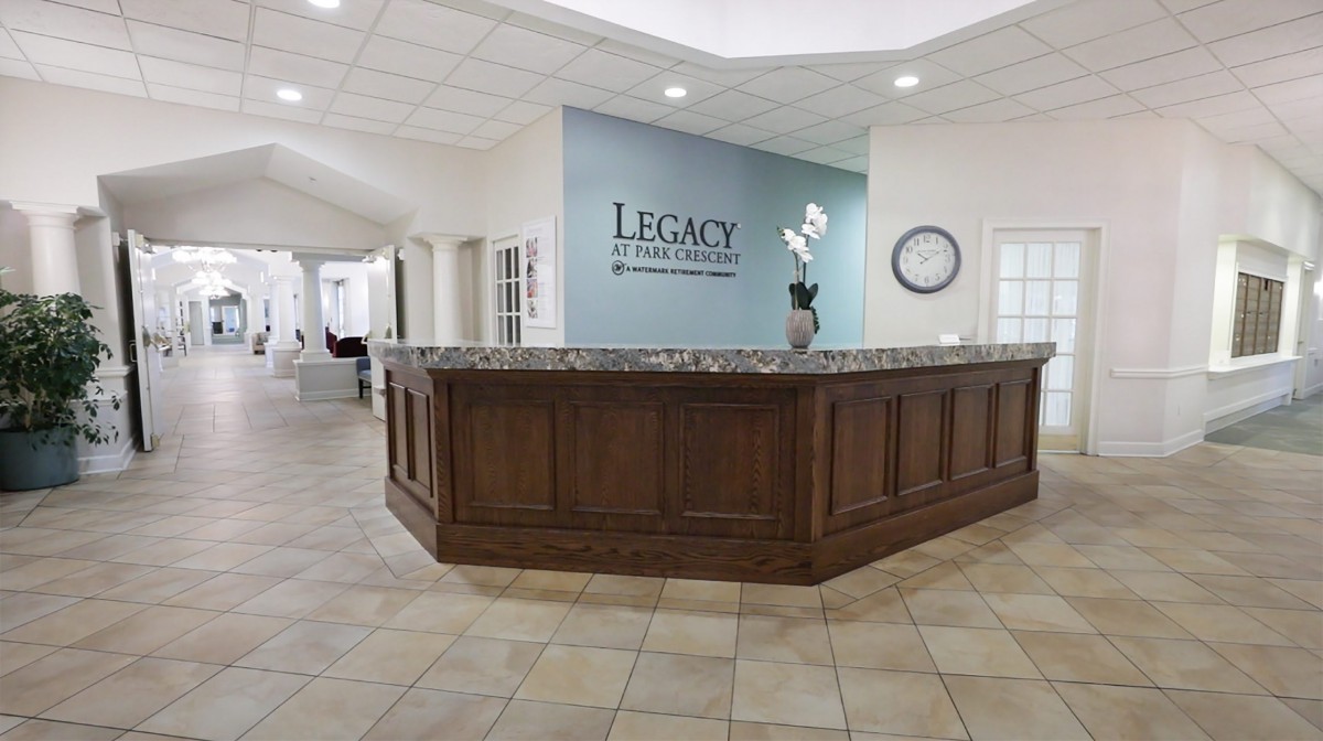 A modern office reception area with a wooden desk and tiled floor.