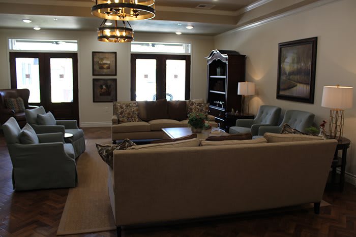 A cozy living room with comfortable sofas, elegant chandeliers, and stylish decor.