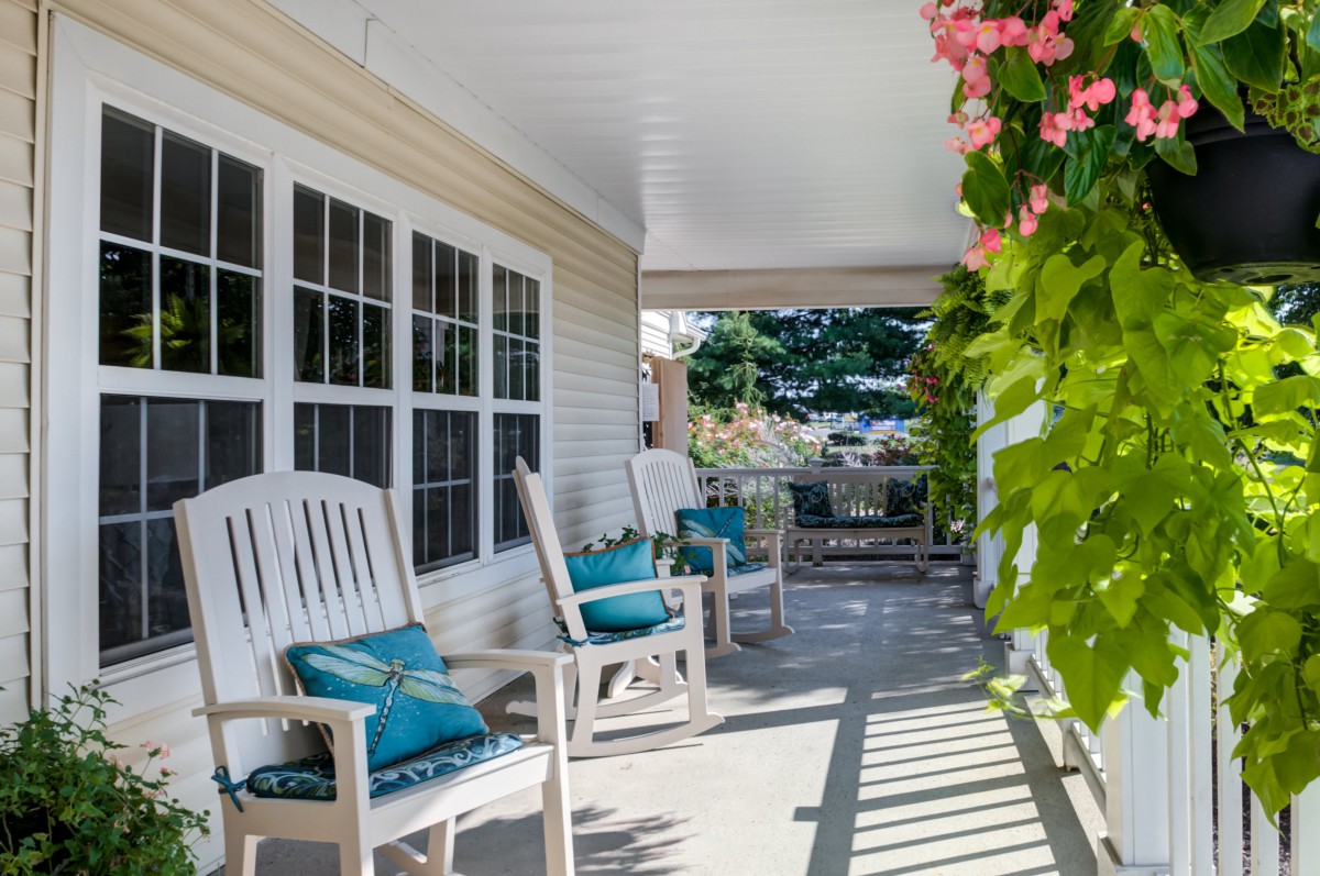 A cozy porch with rocking chairs and vibrant flowers.