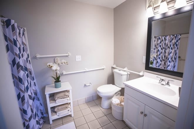 A neatly organized bathroom with a sink, toilet, and decorative elements.