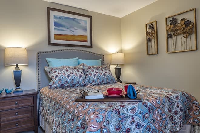 A cozy bedroom with patterned bedding and soft lighting.