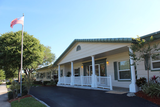 A charming residential building featuring a welcoming front porch and manicured landscaping.