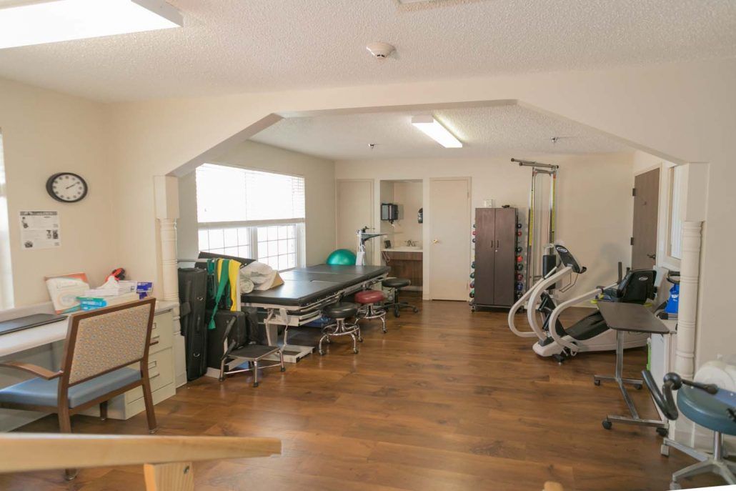 A spacious therapy room equipped for physical rehabilitation.