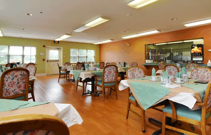An inviting dining room with neatly arranged tables and chairs, set in a warmly decorated interior.
