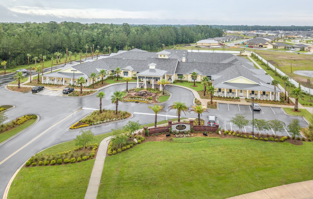 An aerial view of a large building surrounded by lush greenery and winding roads.