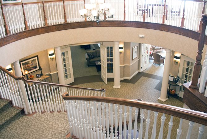 A spacious lobby with a grand staircase and chandelier.