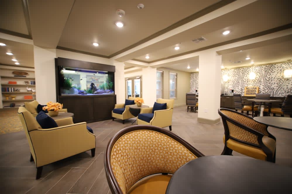 A modern lounge area featuring comfortable seating and a large aquarium.