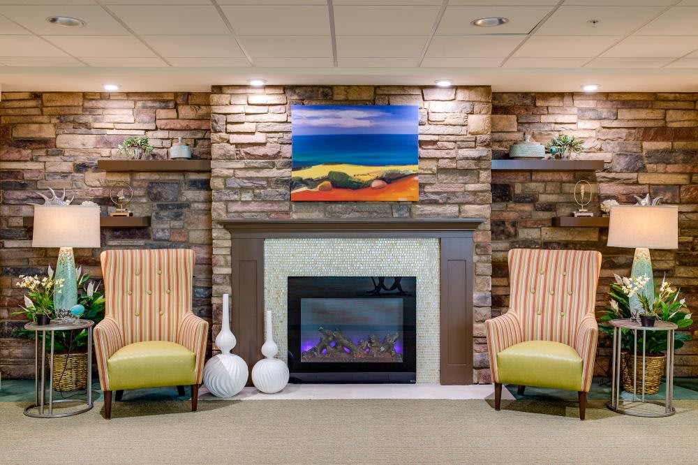 Cozy living room with a stone fireplace and colorful artwork.
