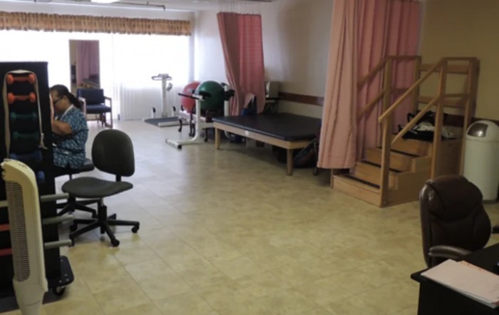 A physical therapy room equipped with rehabilitation equipment and exercise space.