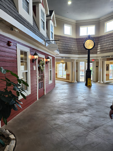 A spacious indoor area featuring a blend of modern architecture and decorative elements, highlighted by a central clock.