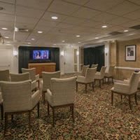 A conference room with arranged seating facing a television.