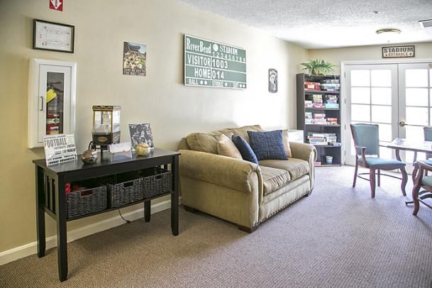 A cozy living room featuring a comfortable sofa, a bookshelf filled with books, and decorative wall art.