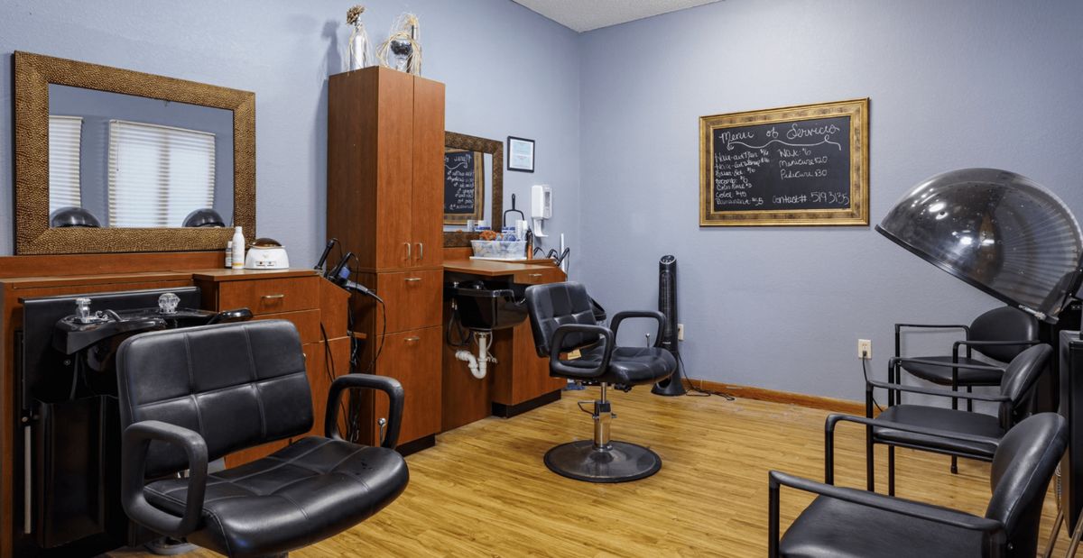 A cozy barbershop interior with chairs and a mirror.