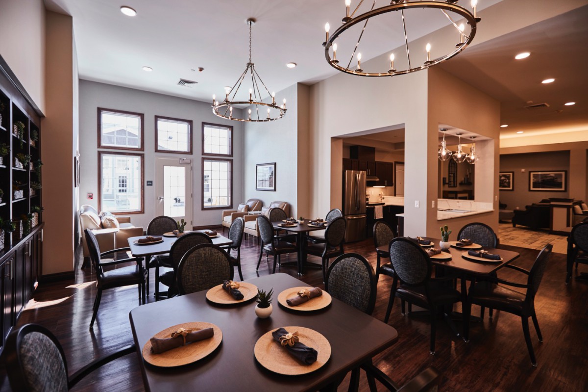 A modern restaurant dining area with elegant furnishings and decorative chandeliers.