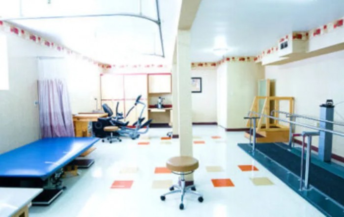 A brightly lit rehabilitation clinic with various therapy equipment.