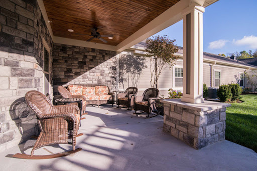 A cozy outdoor patio space featuring comfortable seating and stone accents, perfect for relaxation.