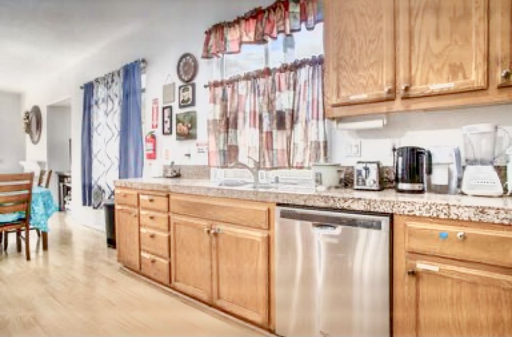 A modern kitchen with wooden cabinets, a countertop, and stainless steel appliances.
