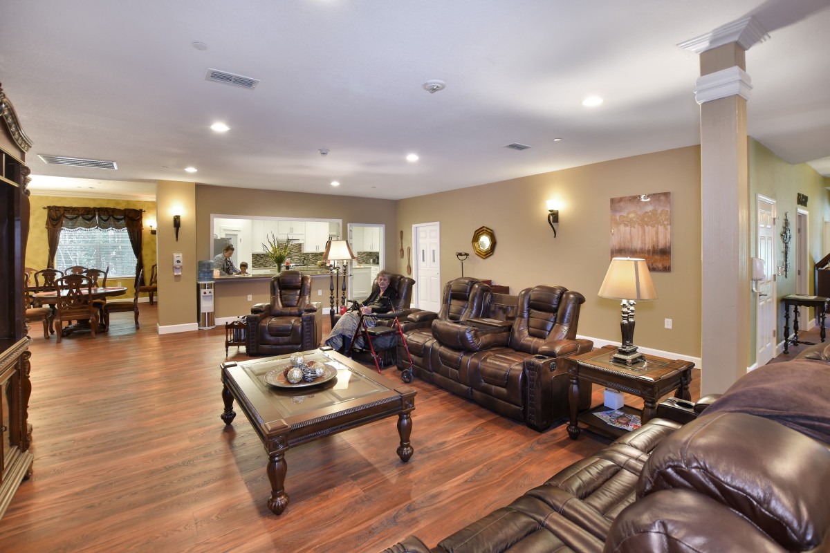 A spacious living room featuring leather sofas, a wooden coffee table, and elegant decor.