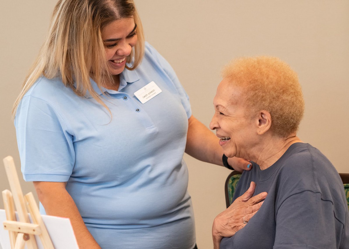 A caregiver shares a moment of support and kindness with an elderly individual.