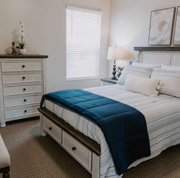 A cozy bedroom with a neatly made bed and stylish decor.