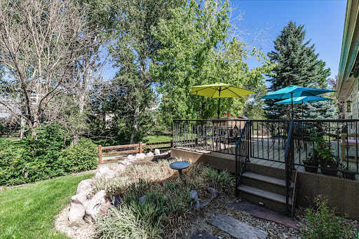 A serene backyard space featuring vibrant umbrellas and lush greenery, perfect for relaxation.