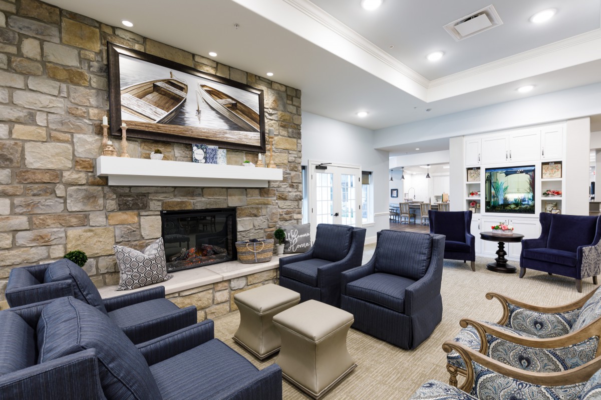 A modern and cozy living room featuring a stone fireplace and comfortable seating.
